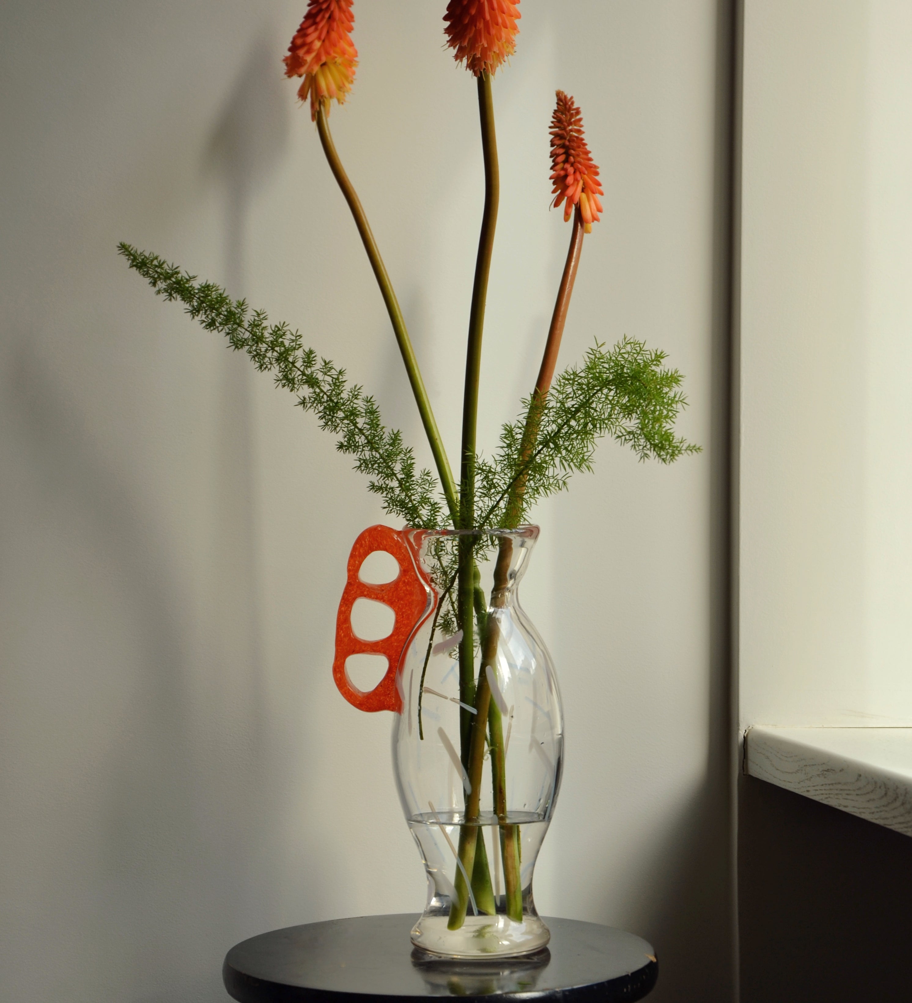 Discover the Modern Vintage Guta Glass Vase with Red Handle – a handcrafted consignment piece, blending traditional craftsmanship with bold modern design.