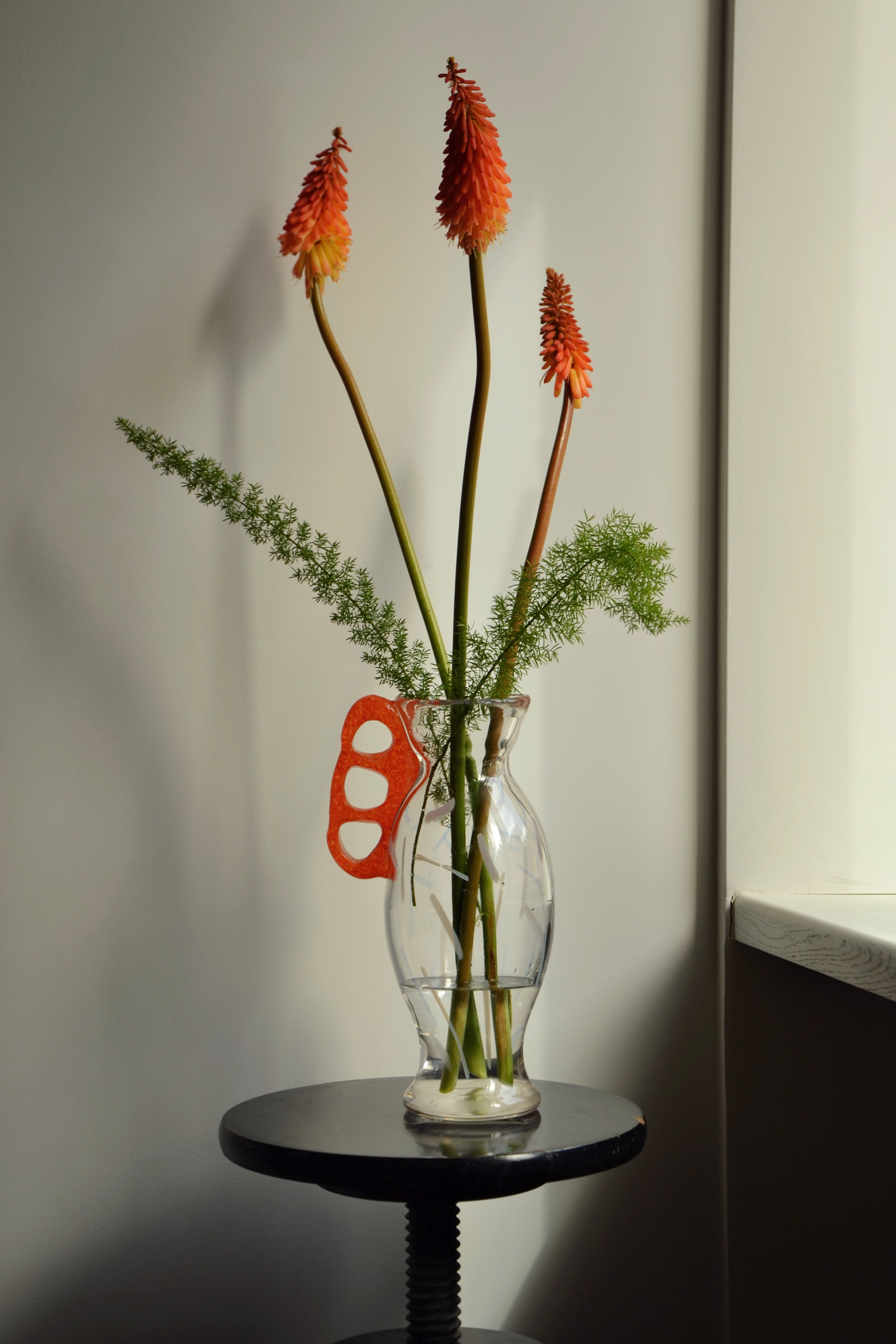 Discover the Modern Vintage Guta Glass Vase with Red Handle – a handcrafted consignment piece, blending traditional craftsmanship with bold modern design.