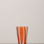Discover the YAKUSH STRIPS Glass Orange – a 5.3" tall, striped orange tumbler made from recycled glass, perfect for summer drinks.