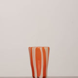 Discover the YAKUSH STRIPS Glass Orange – a 5.3" tall, striped orange tumbler made from recycled glass, perfect for summer drinks.