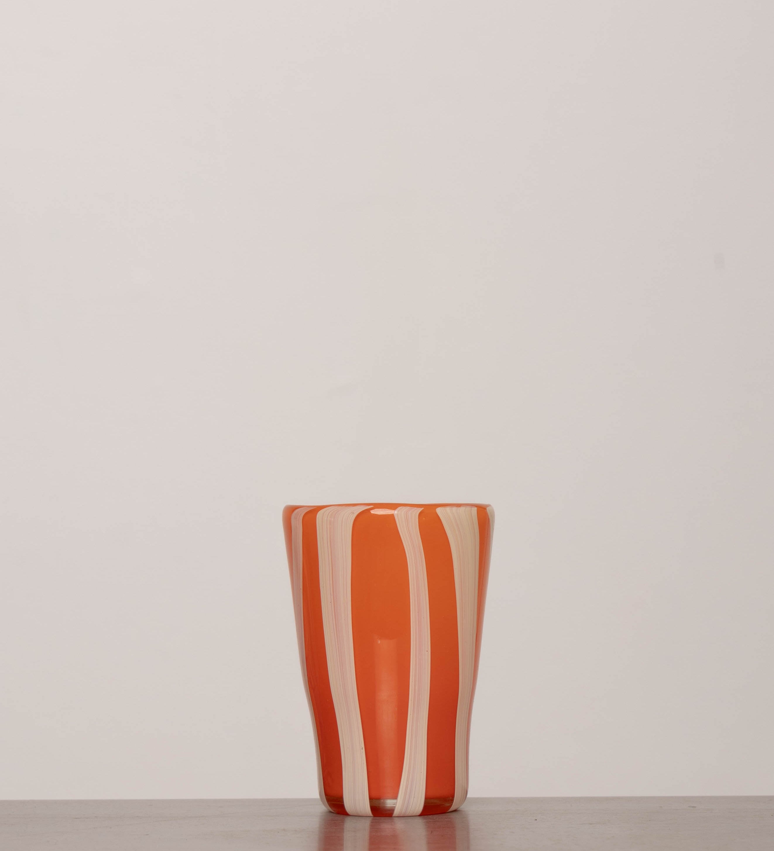 Discover the YAKUSH STRIPS Glass Orange – a 5.3" tall, striped orange tumbler made from recycled glass, perfect for summer drinks.