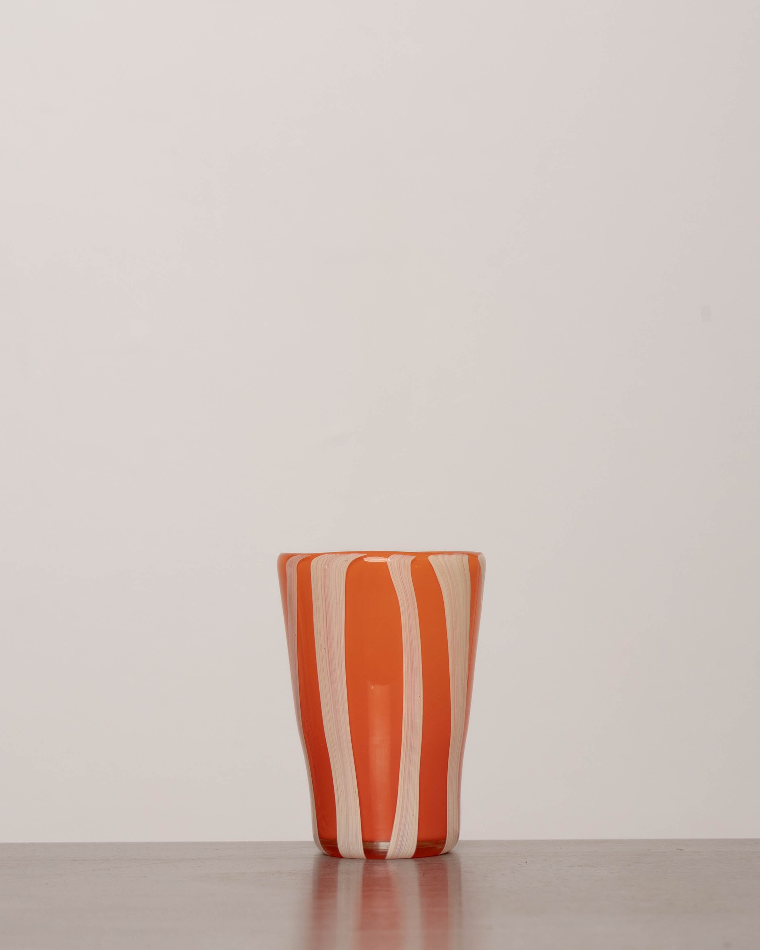 Discover the YAKUSH STRIPS Glass Orange – a 5.3" tall, striped orange tumbler made from recycled glass, perfect for summer drinks.