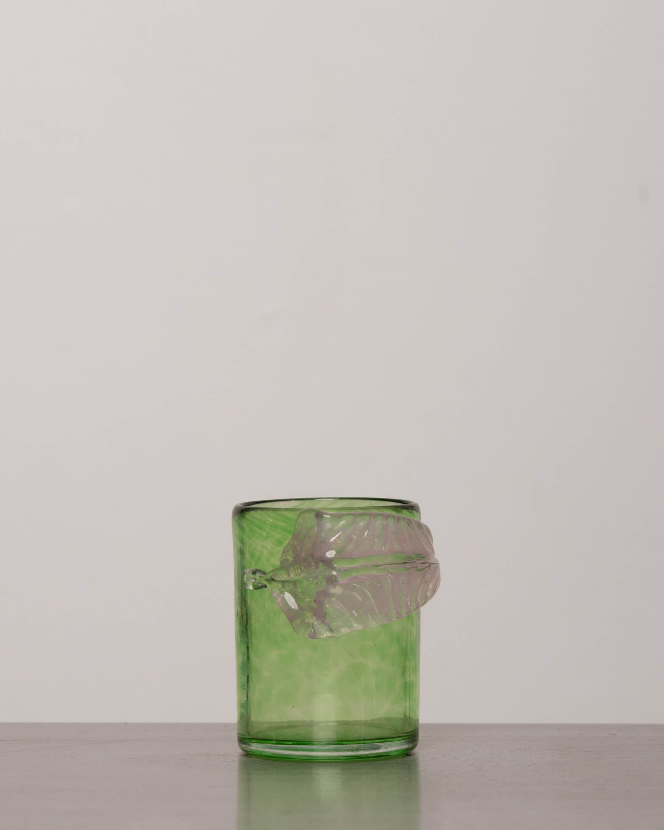 Discover the YAKUSH Botanist Glass Green – a 4.3" tall, 300 ml handcrafted tumbler with a leaf motif, made from recycled hutta glass.