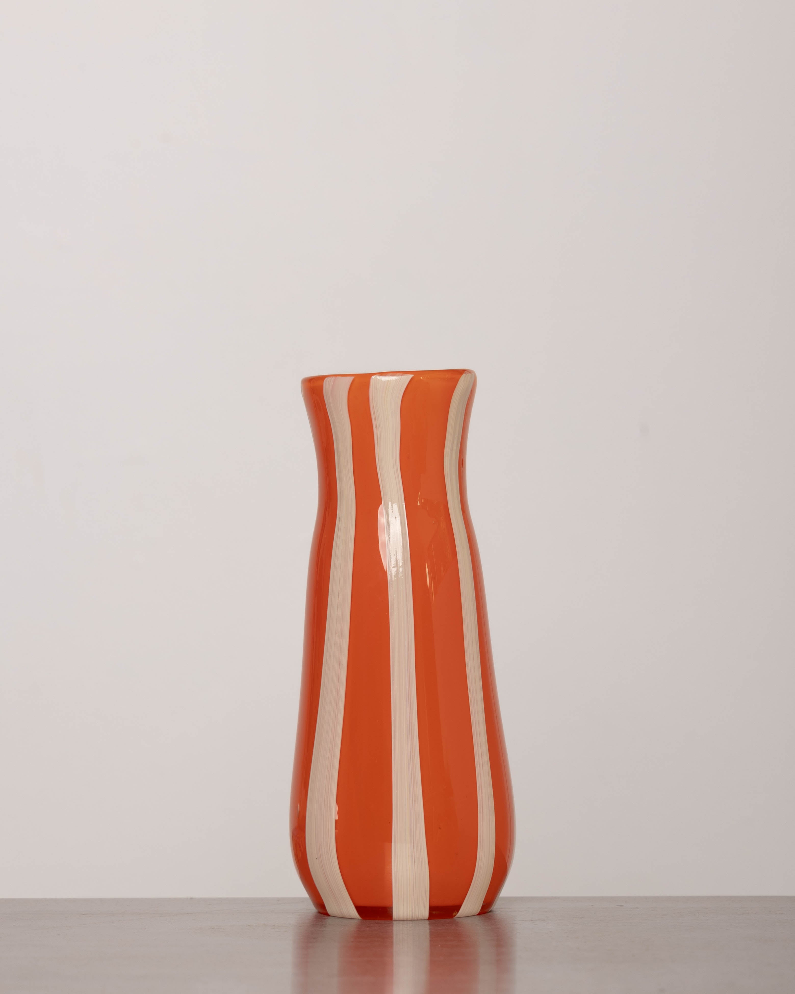 Discover the YAKUSH STRIPS Vase Orange – an 8.6" tall, jam orange striped recycled glass vase, handmade for drinks or floral displays.