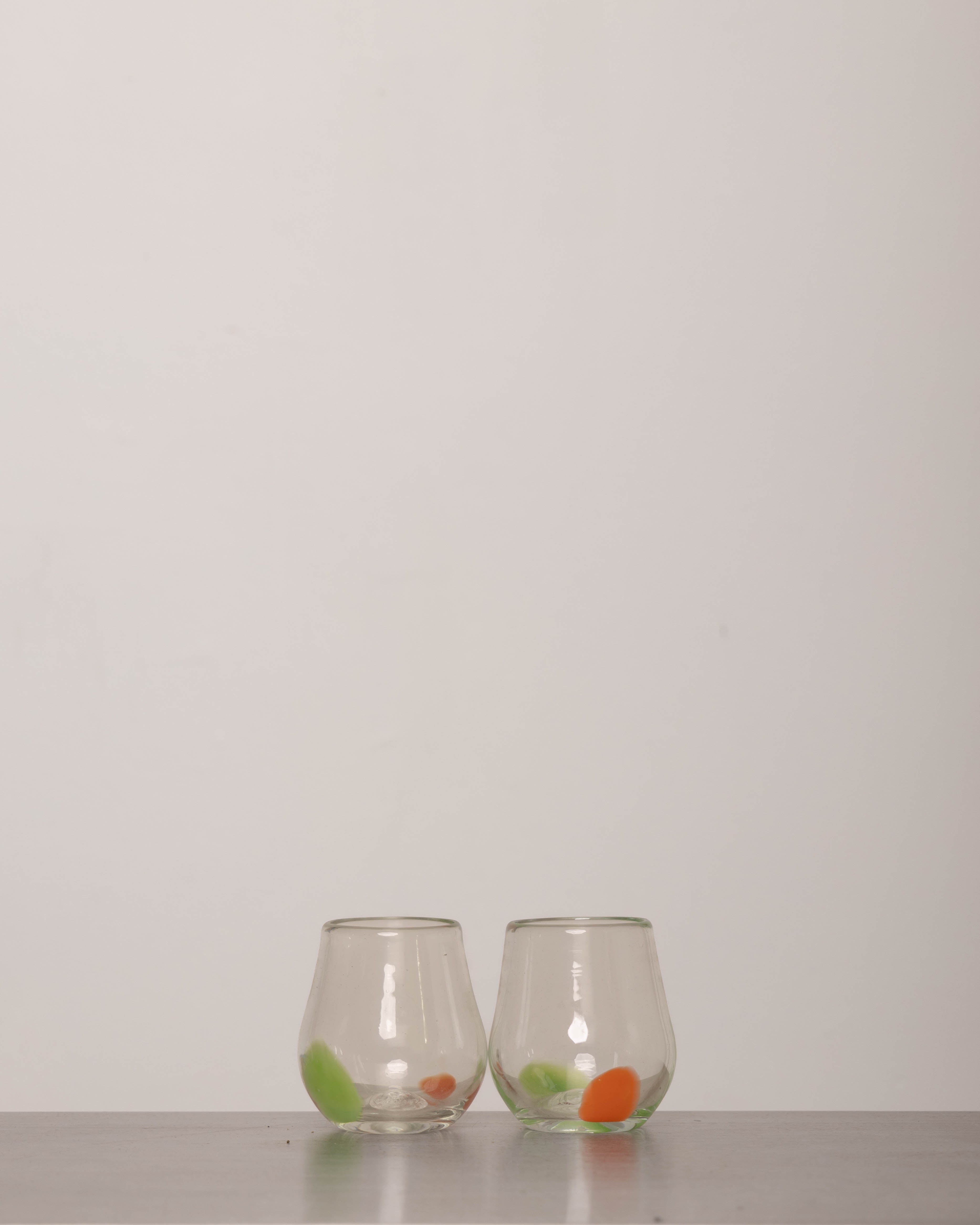 Discover the YAKUSH Tulip Glass – a 3.9" tall, tulip-shaped recycled glass wine glass, handmade with unique color variations.