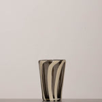 Discover the YAKUSH STRIPS Glass B&W – a 5.3" tall, handcrafted striped glass tumbler made from recycled glass, perfect for summer drinks.
