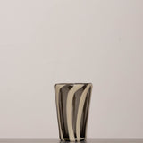 Discover the YAKUSH STRIPS Glass B&W – a 5.3" tall, handcrafted striped glass tumbler made from recycled glass, perfect for summer drinks.